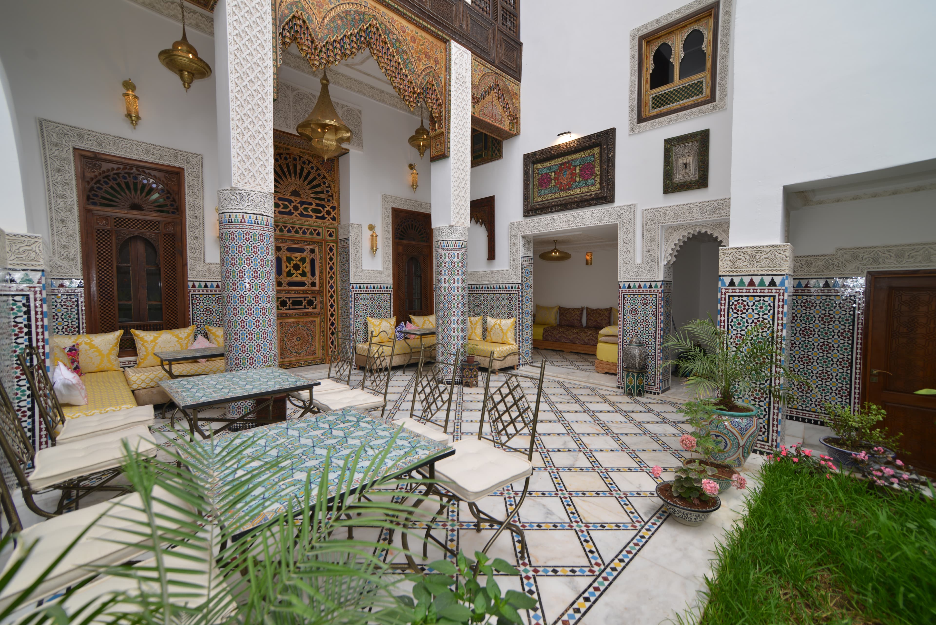Riad Fez Mahal — interior courtyard with zellige tilework, seating and golden lanterns