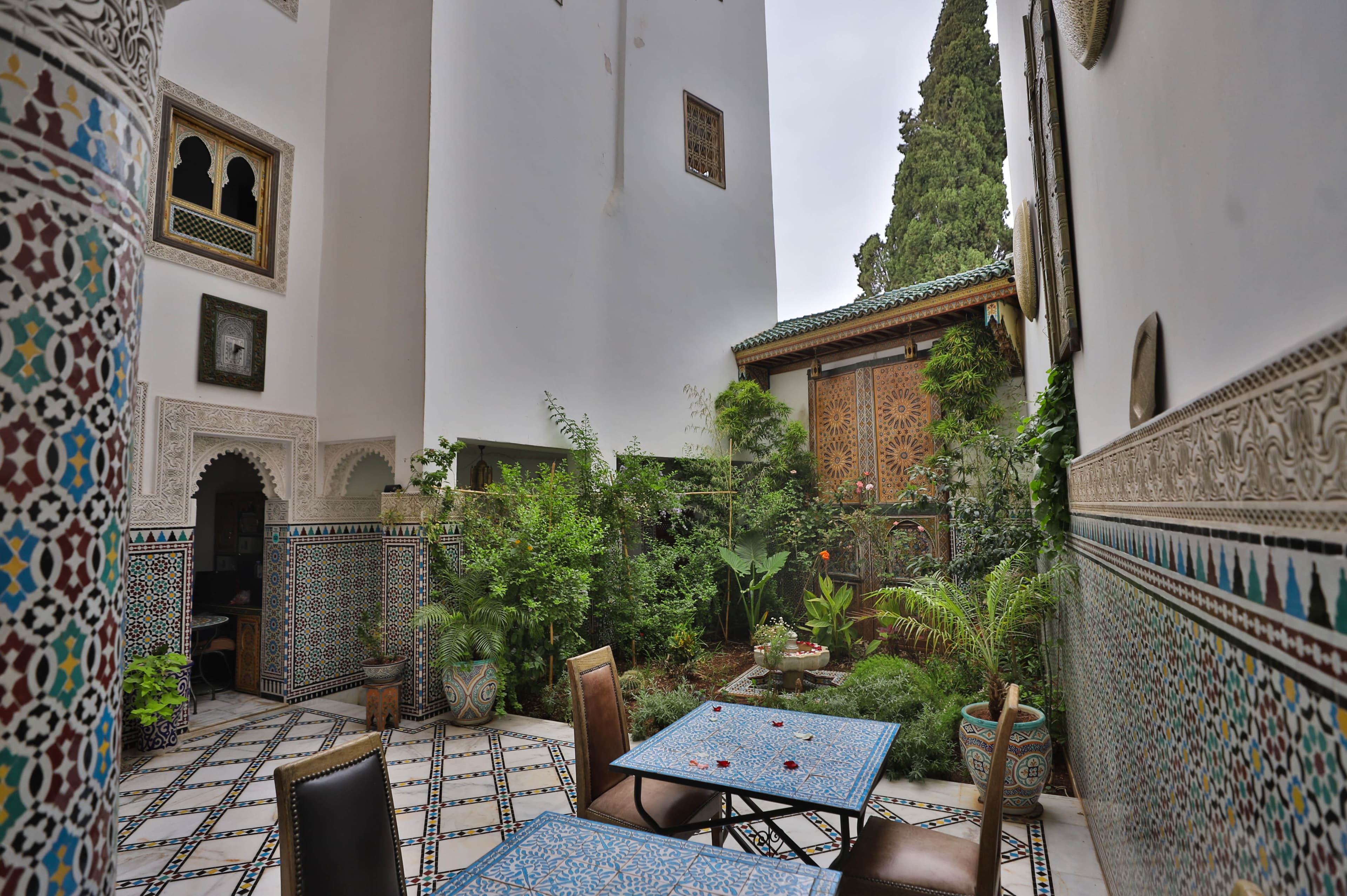 Riad Fez Mahal — courtyard with zellige tilework and mosaic table